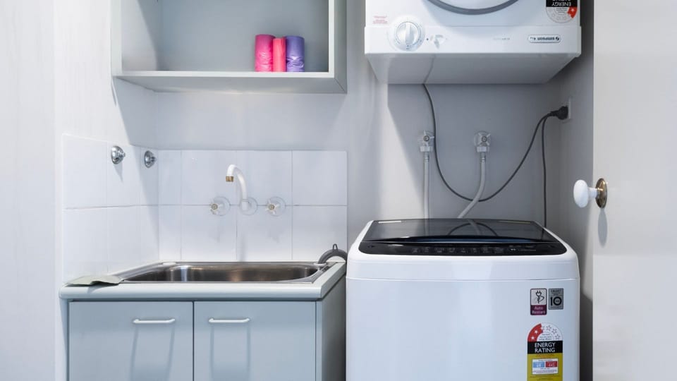 A highly functional laundry utility room cleverly equipped with a separate wash trough and space-saving wall-mounted dryer.