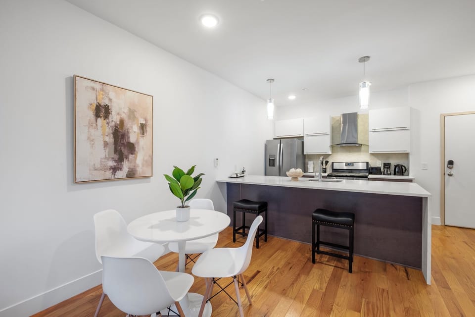 Kitchen and dining area with white quartz island and breakfast bar offering functional workspace.