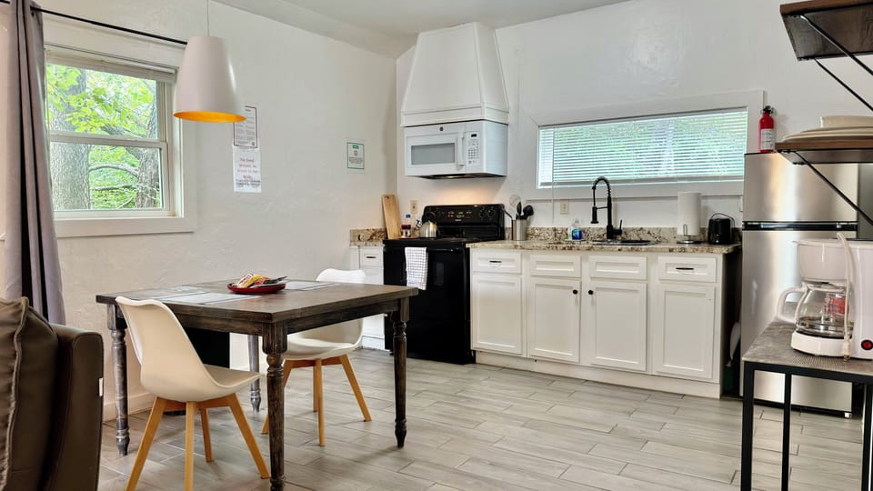 Open kitchen and dining area with modern appliances and a cozy table for enjoying meals together.