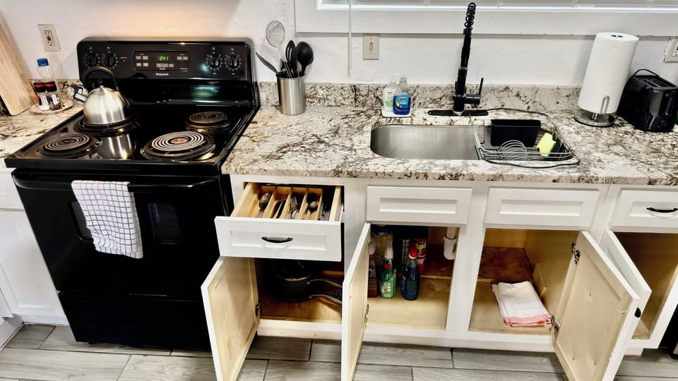 Fully stocked kitchen with cookware, utensils, and cleaning supplies — everything you need for a comfortable stay.