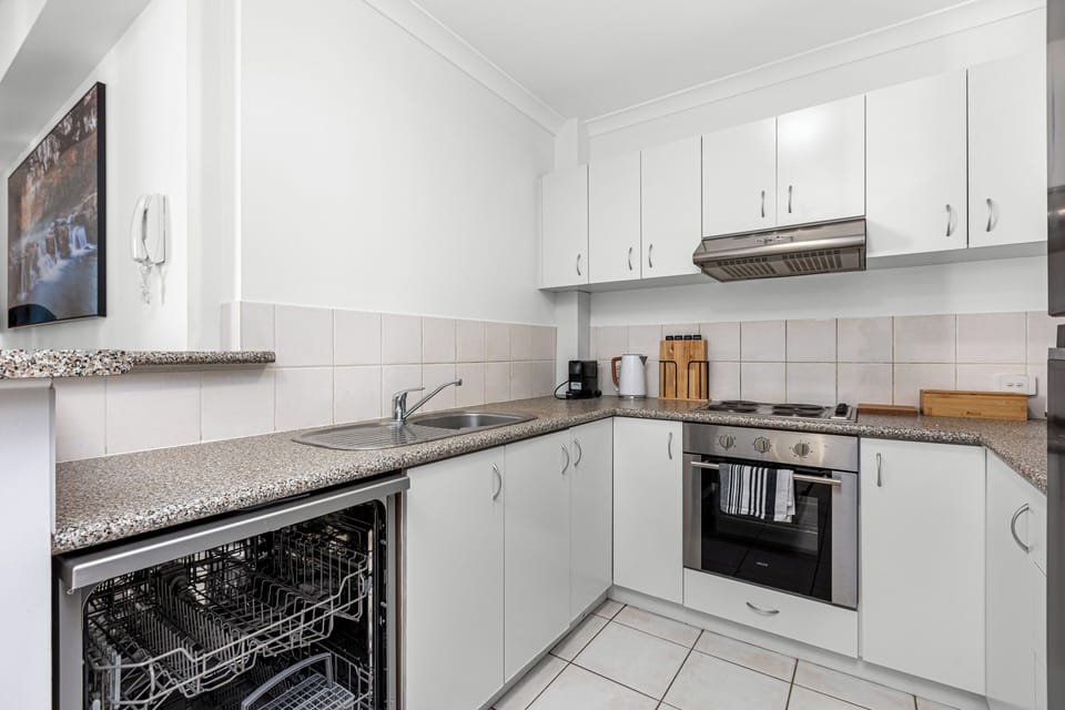 Simplify cleanup in this well-equipped kitchen, featuring a built-in dishwasher and ample counter space.