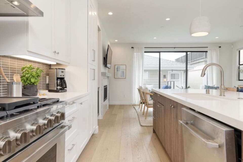 Kitchen features modern appliances and beautiful white finishes.