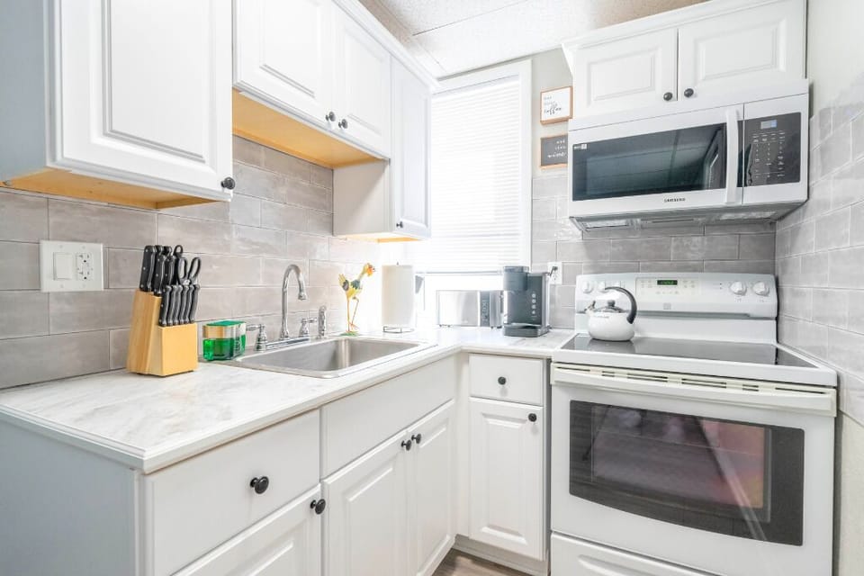 Enjoy the convenience of a fully equipped kitchen with sleek white cabinetry, modern appliances, and all the essentials for home-cooked meals or a quick morning coffee. Bright, functional, and perfect for extended stays.