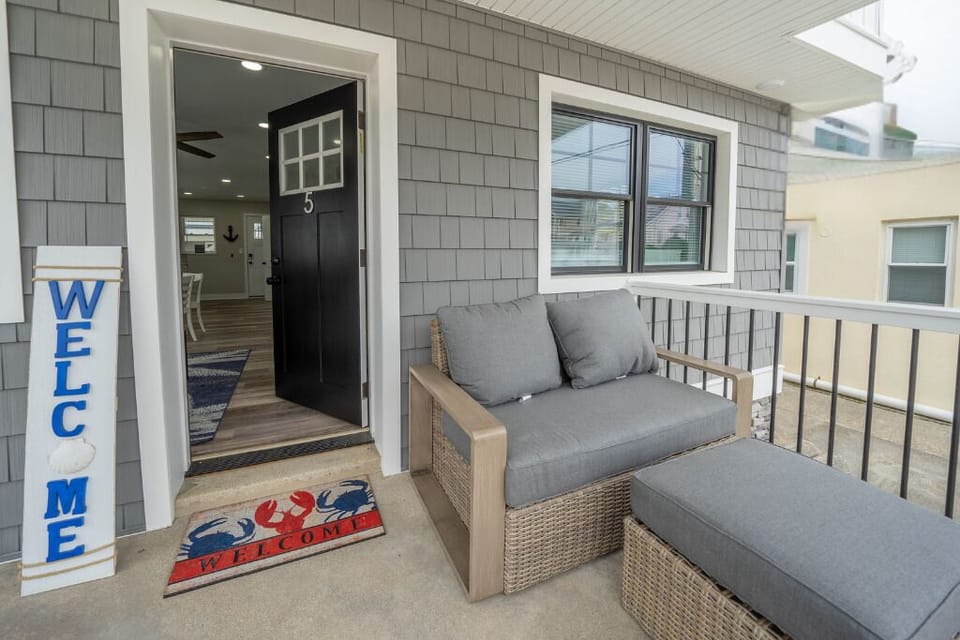 Unwind on the private front porch with cozy seating and peaceful street views - the perfect spot for morning coffee or an evening glass of wine.