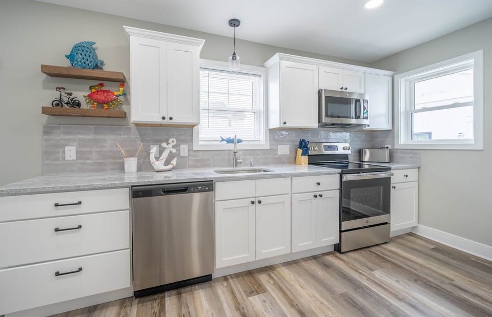 Bright and beachy kitchen with stainless steel appliances, nautical décor, and modern finishes. Perfect for cooking up vacation meals with ease and style.