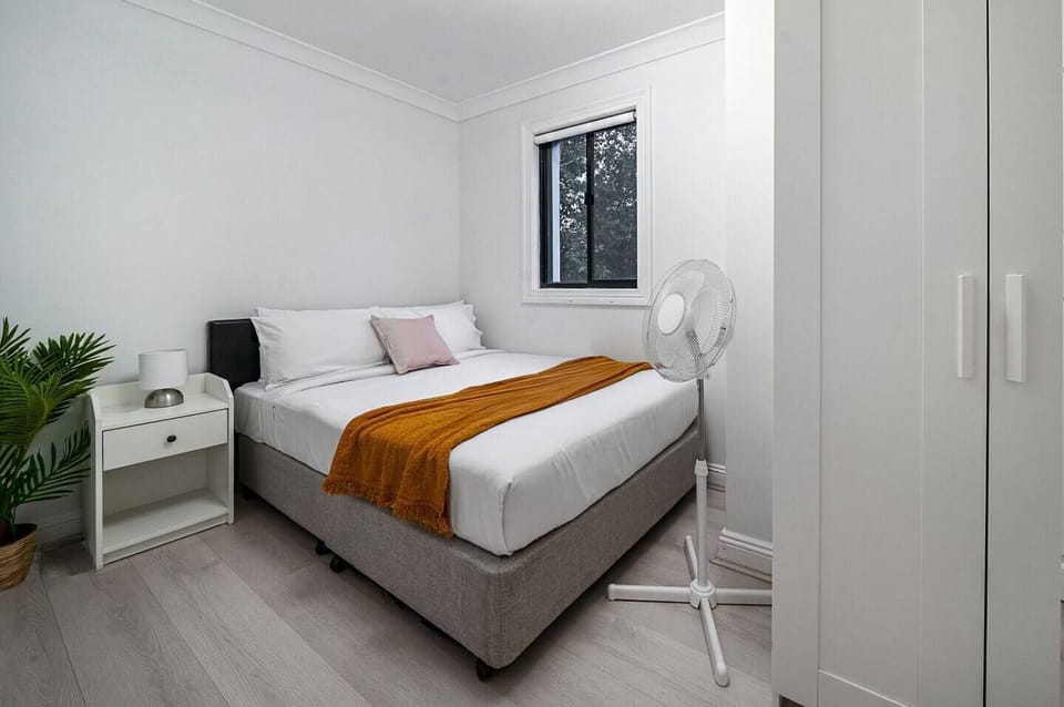 Escape to the third bedroom, where a double bed dressed in fresh linens and a portable fan ensure comfort throughout your sleep.