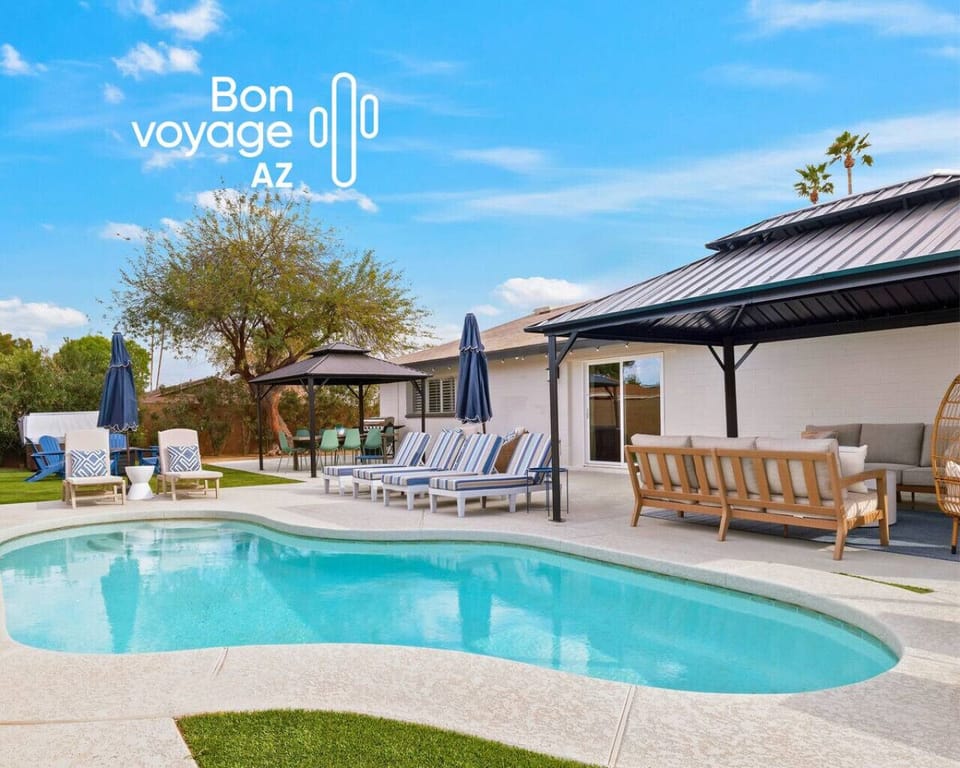 Resort-style backyard with heated pool, hot tub, fire pit, shaded gazebos, and sun loungers, designed for total relaxation.