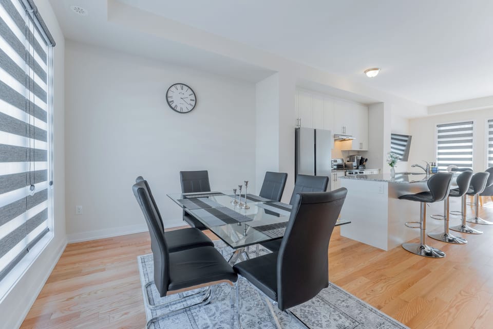 Stylish black leather chairs complement the sleek glass table.