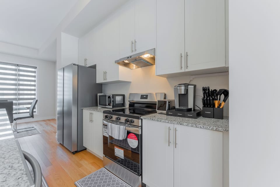 A fully-equipped kitchen with a coffee machine and two microwaves.