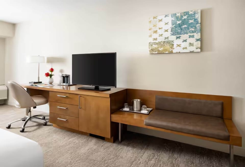 Unwind in a bright room with desk, TV, and sofa.