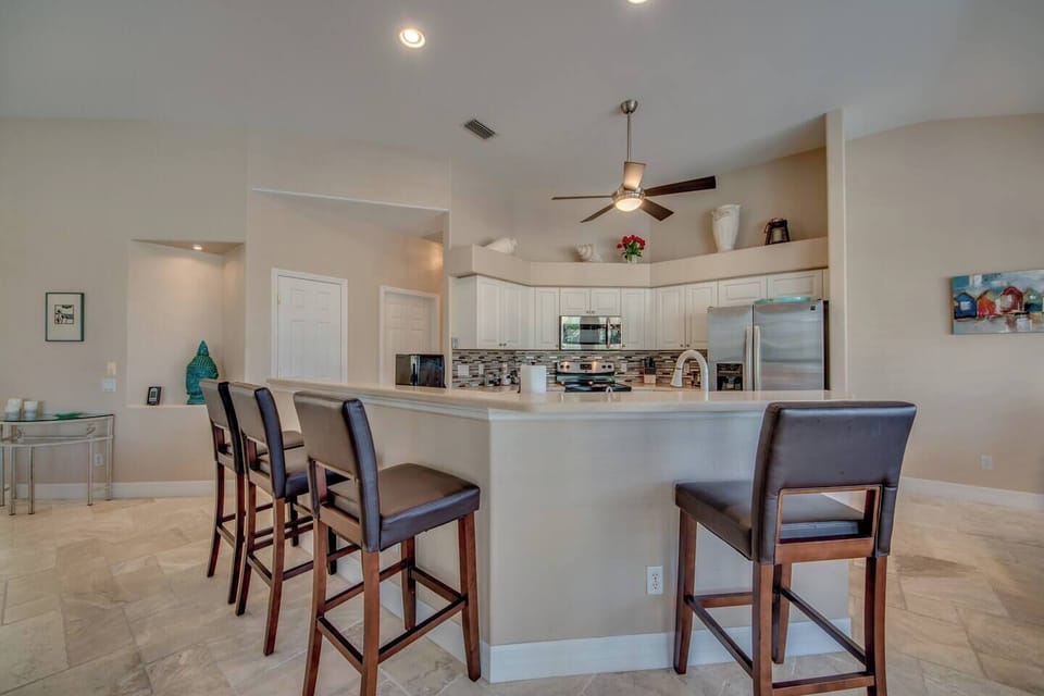 Large kitchen with stainless steel appliances and bar stools for 4 people (4)