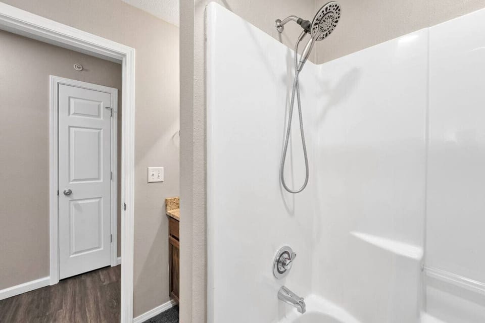 Hall bath with a tub and shower, right by the bunk room and the second bedroom.