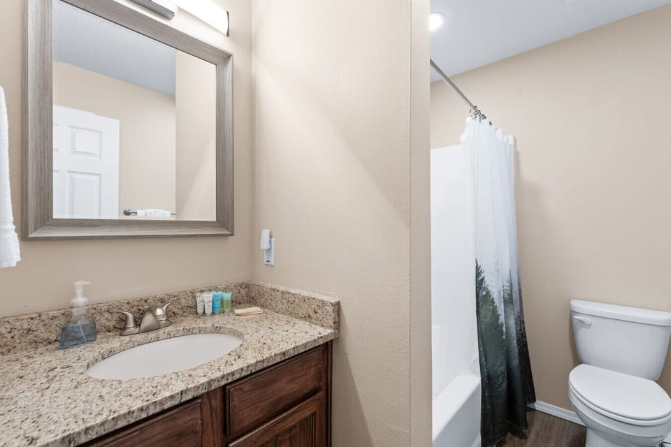 Hall bath with a tub and shower, right by the bunk room and the second bedroom.