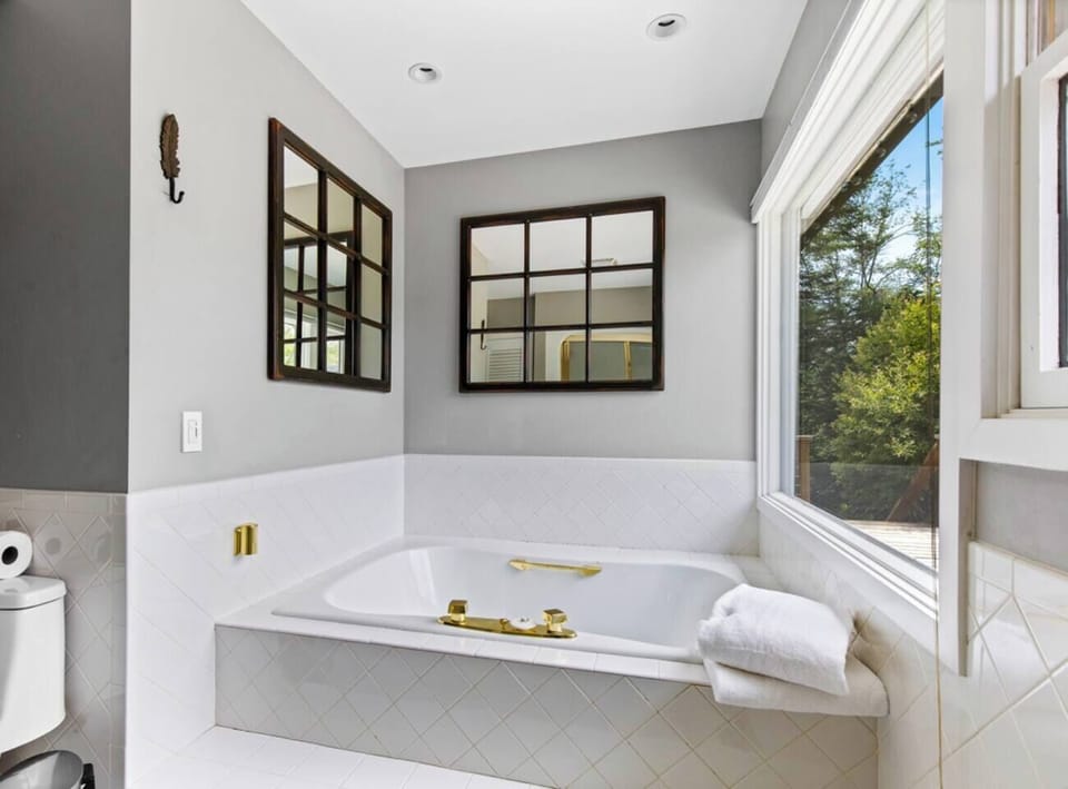 Master bath with jetted tub overlooking the view of the hills and pond below.