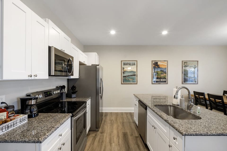 Fully equipped modern kitchen with stainless steel appliances, granite countertops, and ample space.