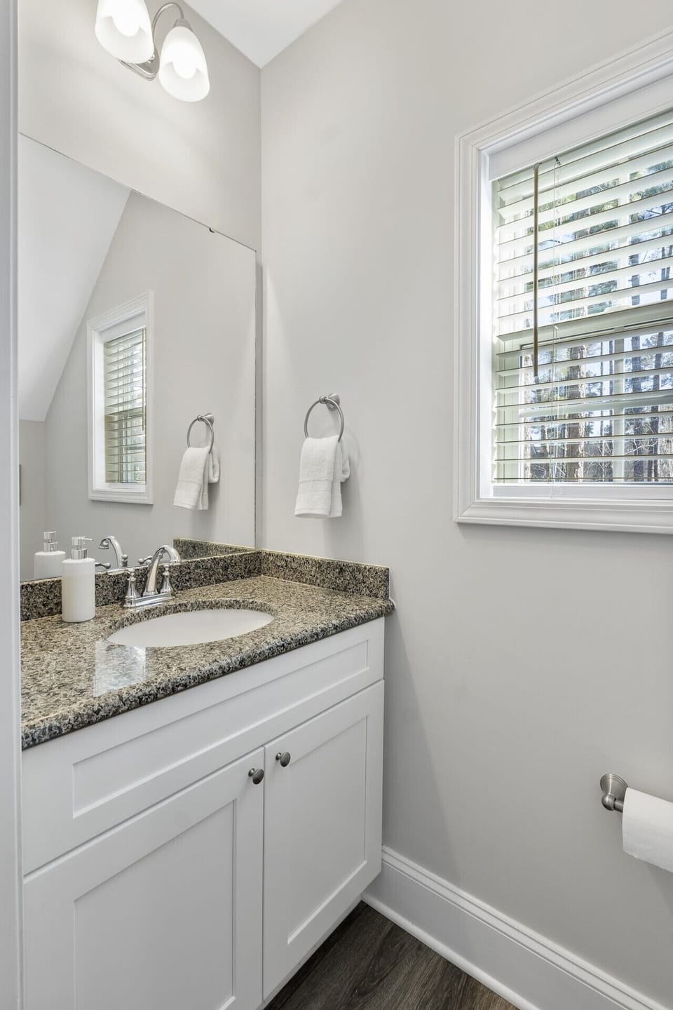 Modern and spacious bathroom featuring a sleek double vanity and ample lighting.