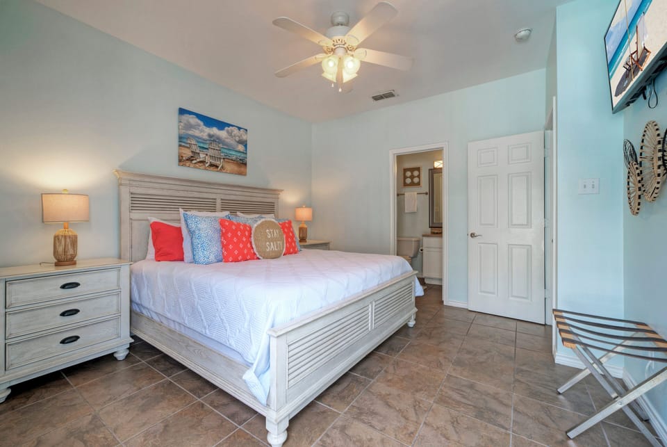The primary bedroom features a king bed, TV, balcony, and an ensuite bathroom. (Costa Bahia 207)