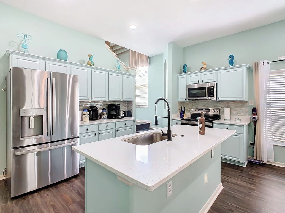 - Fully equipped kitchen with stainless steel appliances and beachy blue cabinetry
- Brew your favorite cup with the coffee station stocked for your convenience
- Generous counter space and modern sink setup perfect for home style cooking