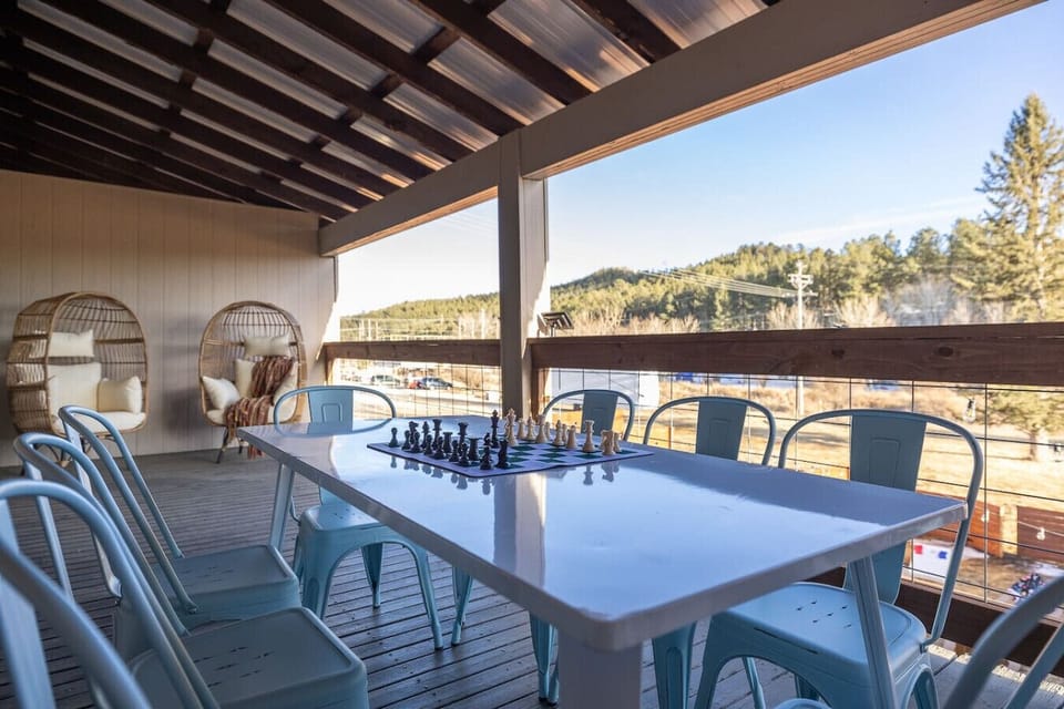 A spacious wooden deck featuring elegant tables and chairs, ready for outdoor dining or a peaceful retreat.