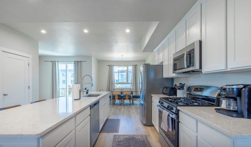 Modern kitchen featuring full appliances, island counter, and natural light.