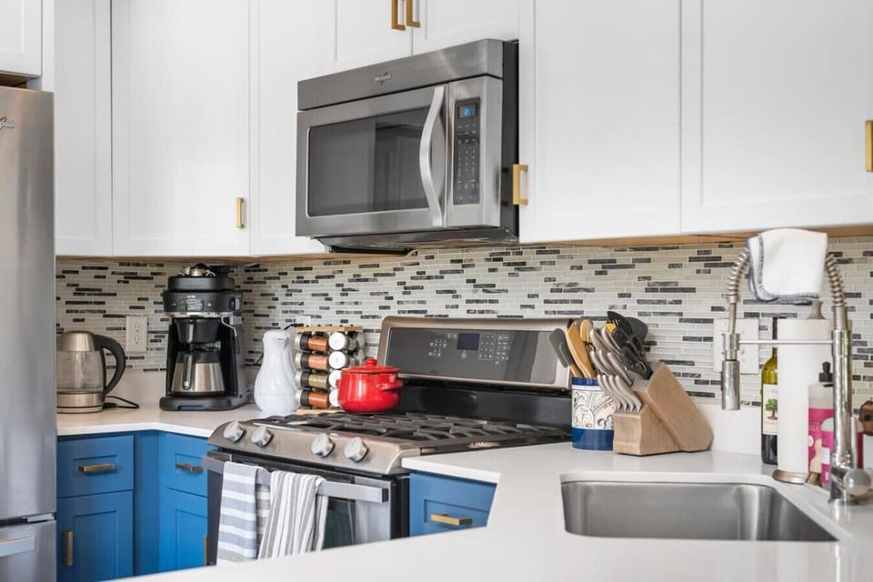 Kitchen features stainless steel appliances + coffee maker