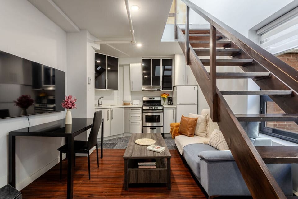 Contemporary setup with smart TV, dining space, and a chic staircase centerpiece