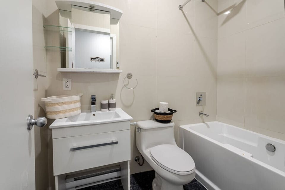 Fresh and modern bathroom with a full tub, sleek vanity, and essential touches