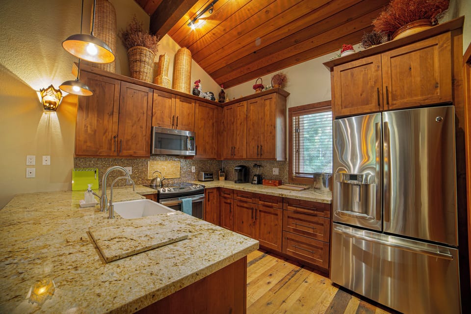 Fully stocked chef kitchen. Stainless appliances, kitchen island with bar stools seating with the modern mountain vibe