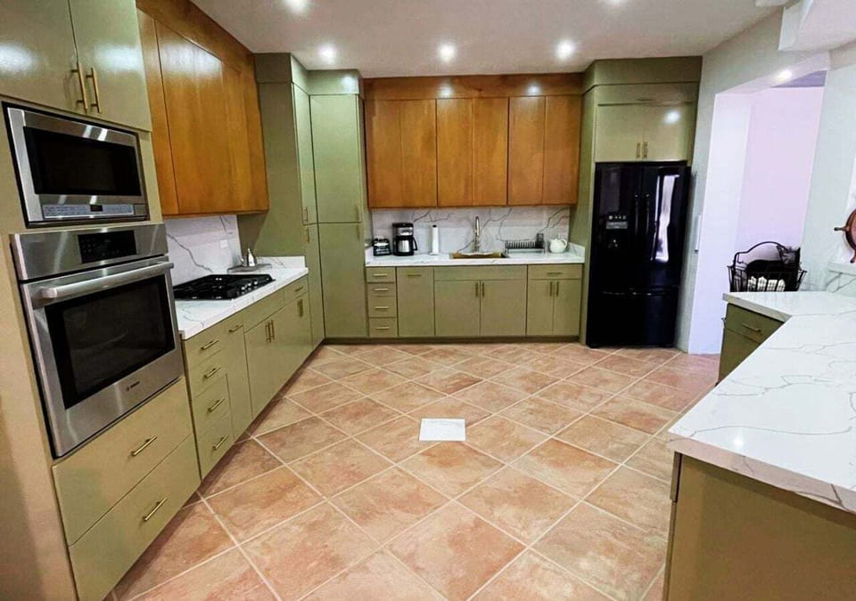 The kitchen is fully equipped with a refrigerator, microwave, and oven, plus essential cookware and kitchenware — designed for convenient meal preparation during your stay