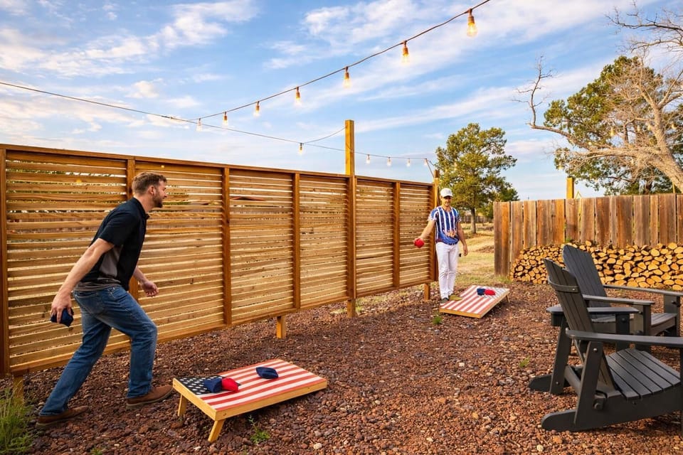 Private backyard with cornhole, string lights, and cozy lounge seating