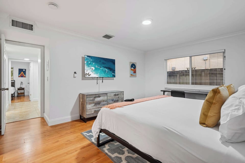 Bedroom with king bed, smart TV and dresser.