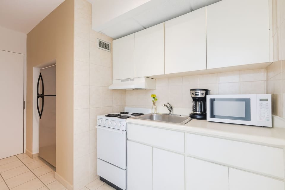 Bright and fully equipped kitchenette with stove, microwave, and coffee maker — perfect for preparing light meals during your stay.