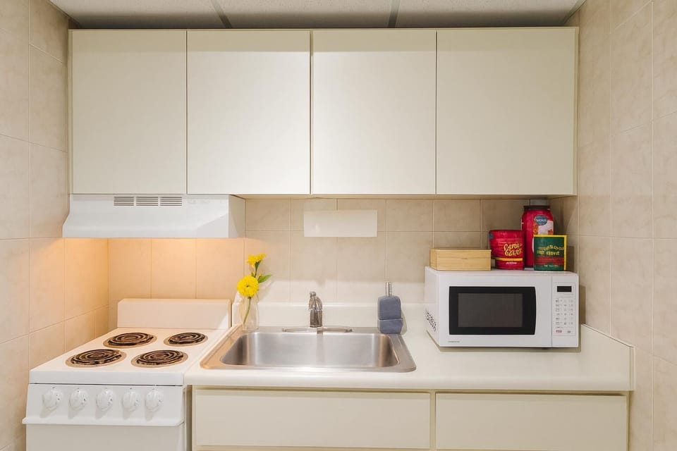 Bright and fully equipped kitchenette with modern essentials—perfect for preparing quick meals or enjoying your morning coffee in comfort.