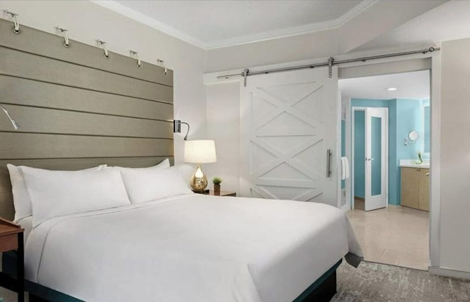 Primary bedroom with view into the spacious and accommodating main bath.