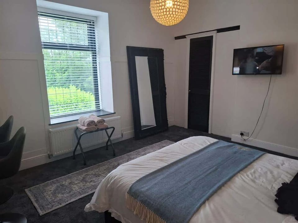 Main bedroom with storage
Additional view of the main bedroom highlighting wardrobe/storage space and natural light, ideal for longer stays at Hosterooo (Rochdale).