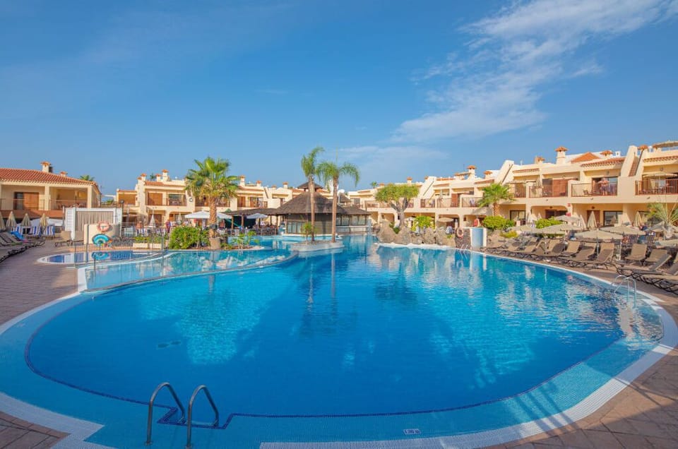 Tranquil resort pool reflecting the beauty of the early morning sky.