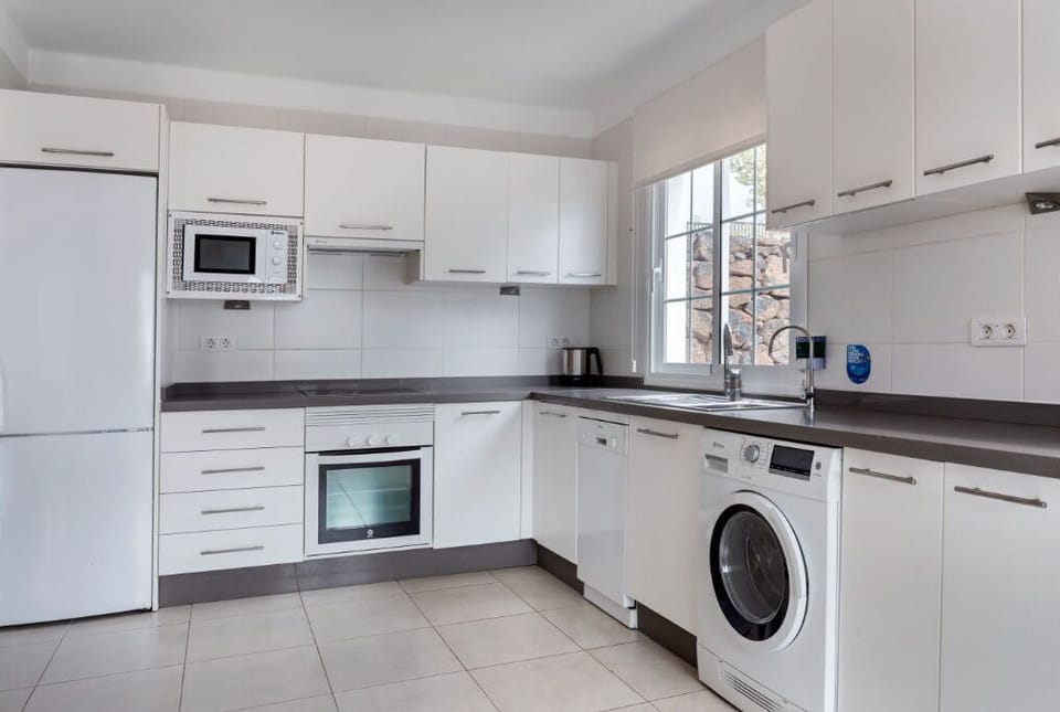 Streamlined and efficient kitchen space, complete with laundry facilities for your convenience.