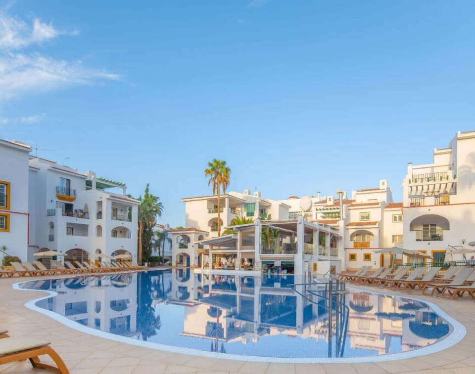Spacious poolside paradise with lush palm landscapes.