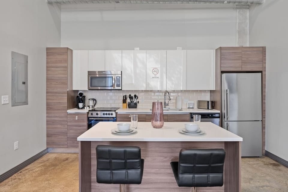 KitchenModern kitchen in Dallas with island seating, subway tile & sleek cabinetry—minimal retreat blending function and style.