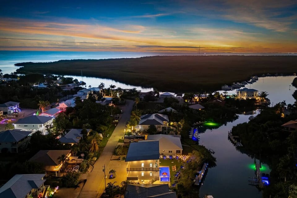 Aerial view of the home and canal captured in the golden light of late afternoon.