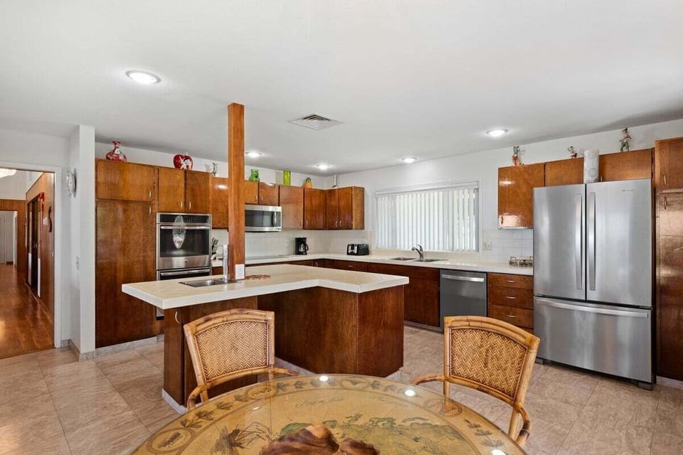 Elegant kitchen-dining combo with natural light and seamless outdoor link.