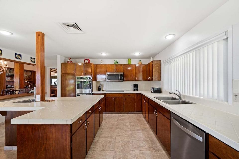 Spacious kitchen with ample counter space, stainless steel appliances, and warm wood cabinetry.