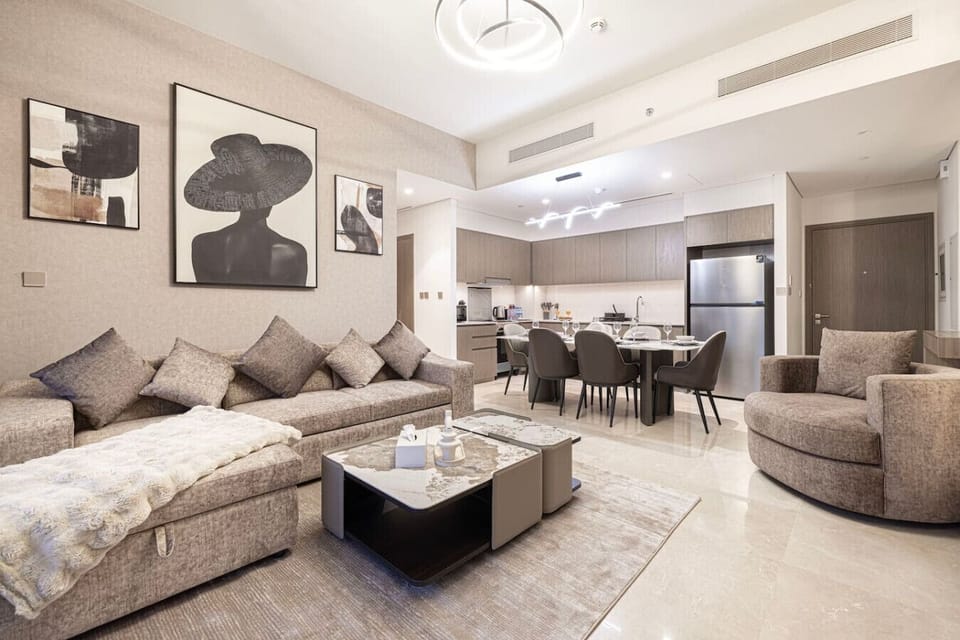 Step into a spacious, modern living room designed for comfort and style, featuring chic furnishings and large windows with stunning Downtown Dubai views. The perfect space to relax and enjoy your luxury stay.