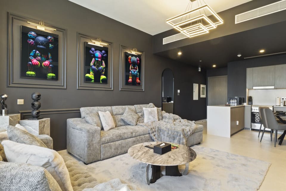 Cozy living room featuring a comfortable sofa bed and stylish portraits on the wall—perfect for families or groups seeking a luxury stay in Downtown Dubai.