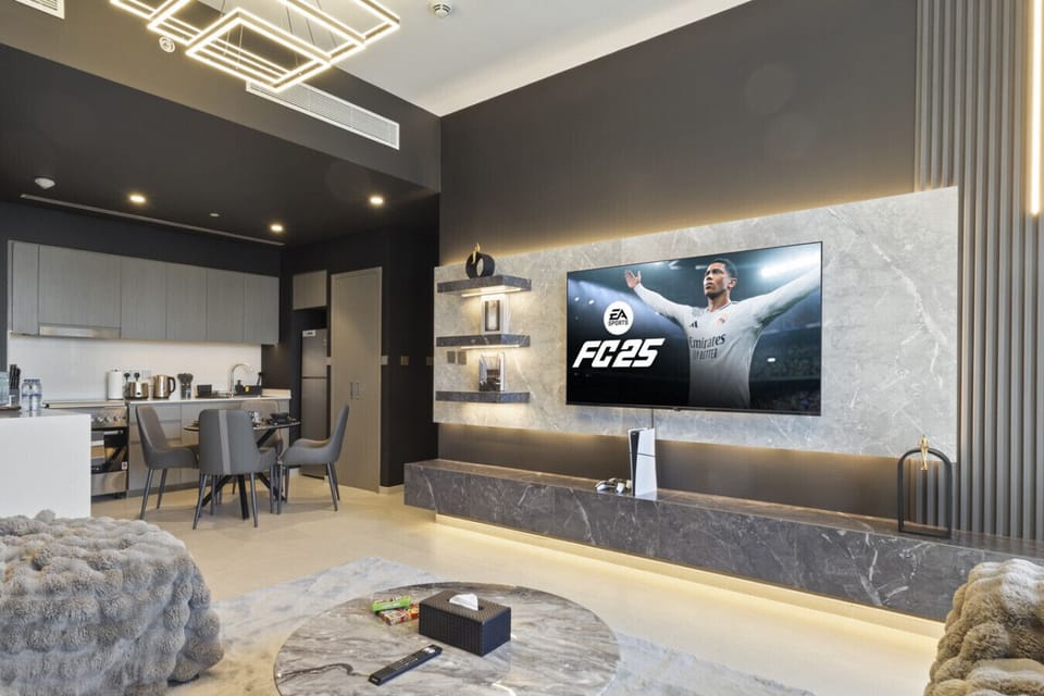 Spacious living room with a smart TV, elegant dining area, and modern ceiling lighting. Ideal for relaxation and meals, this stylish space offers both comfort and luxury, all with stunning views of Downtown Dubai.
