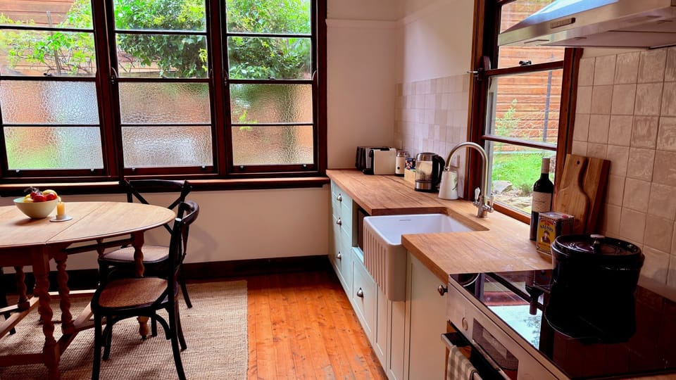 Light-filled country kitchen with an antique oak table for relaxed meals.