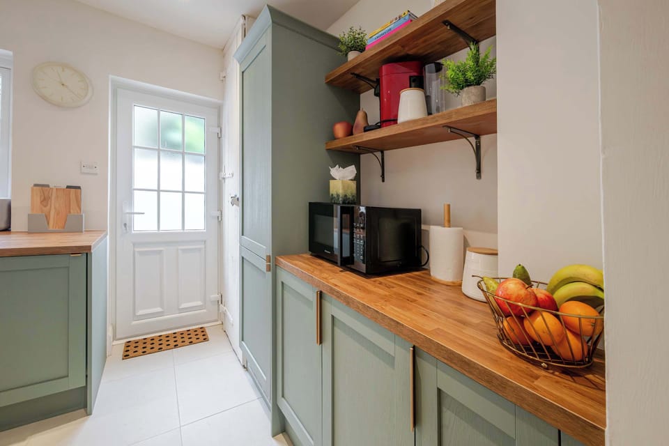 This kitchen includes an oven and hob, microwave, fridge freezer, dishwasher, washer dryer, coffee machine, toaster, and kettle. 
