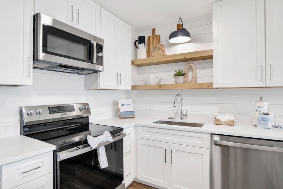 East - Fully equipped kitchen with stainless steel appliances and granite counters