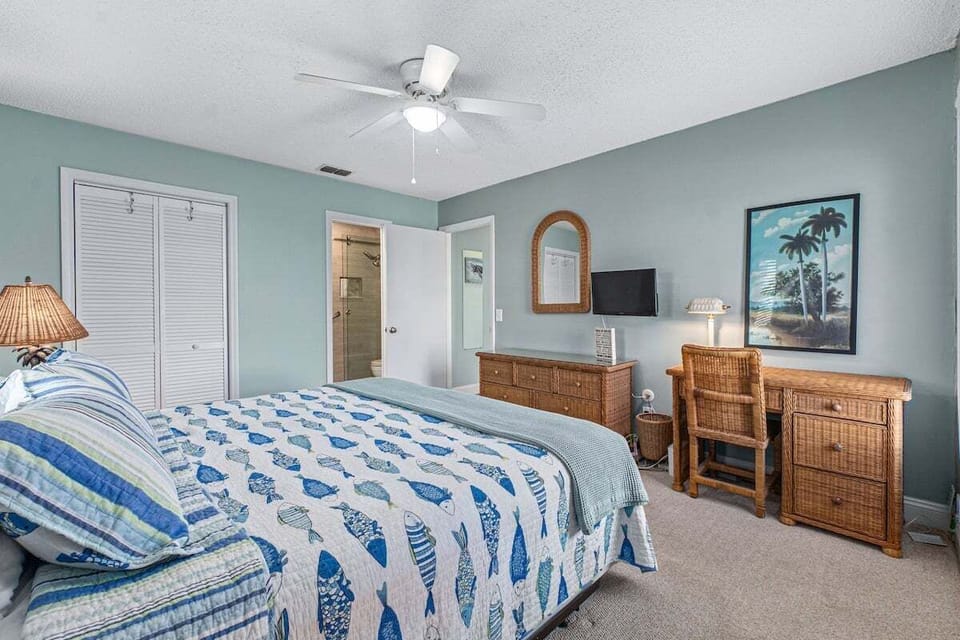 The ensuite Bedroom 1 offers a comfortable and stylish retreat, featuring a plush king-sized bed, a TV for entertainment, and a spacious closet for all your essentials. A ceiling fan adds comfort, ensuring a relaxing stay.