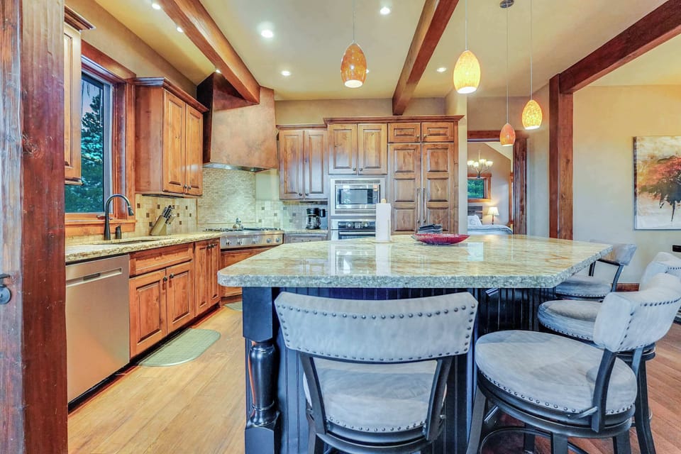 Large Chef inspired kitchen with gas stove, wine refrigerator, and expansive counter space.